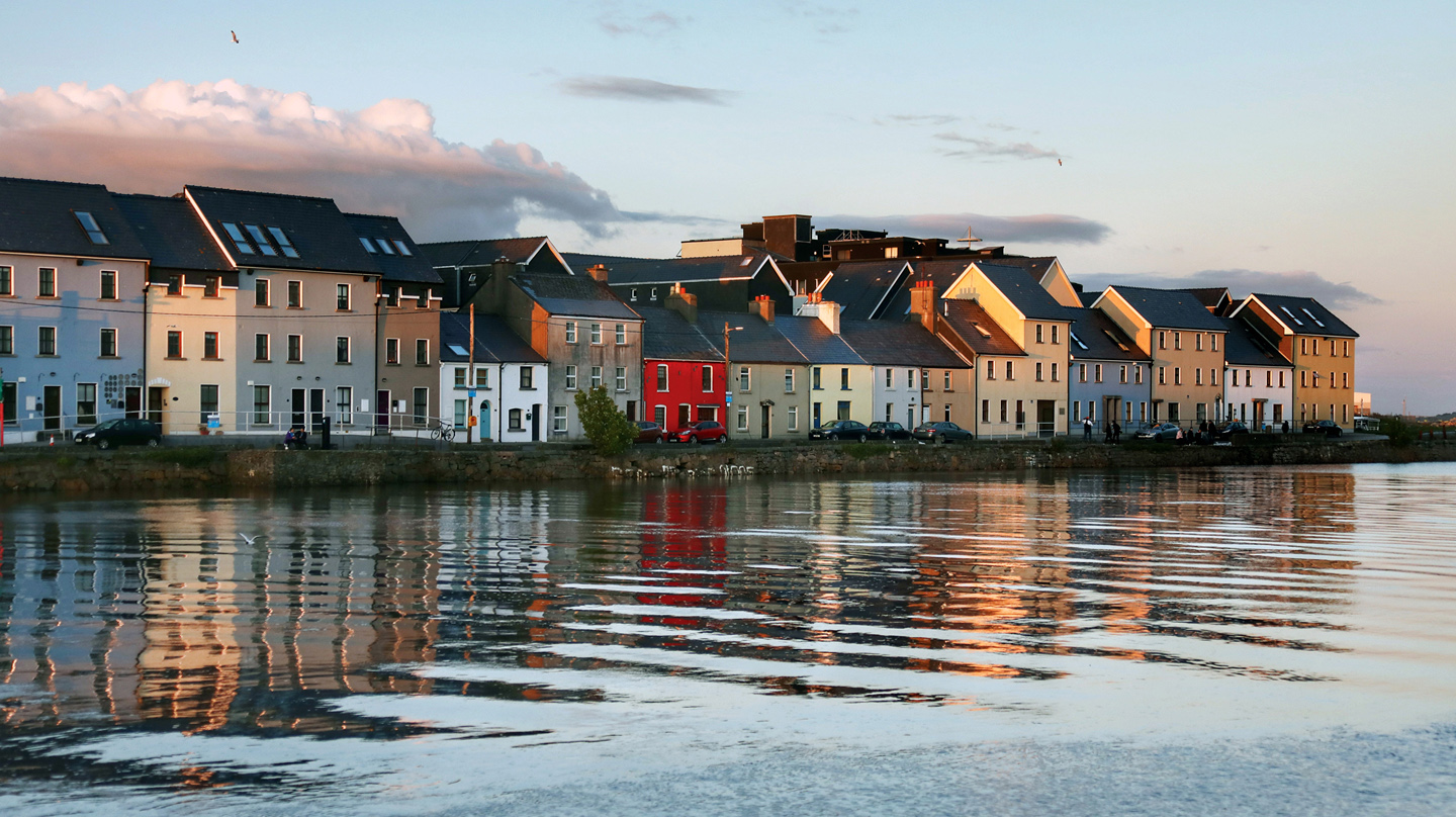 Houses by the ocean along the Long Walk in Galway