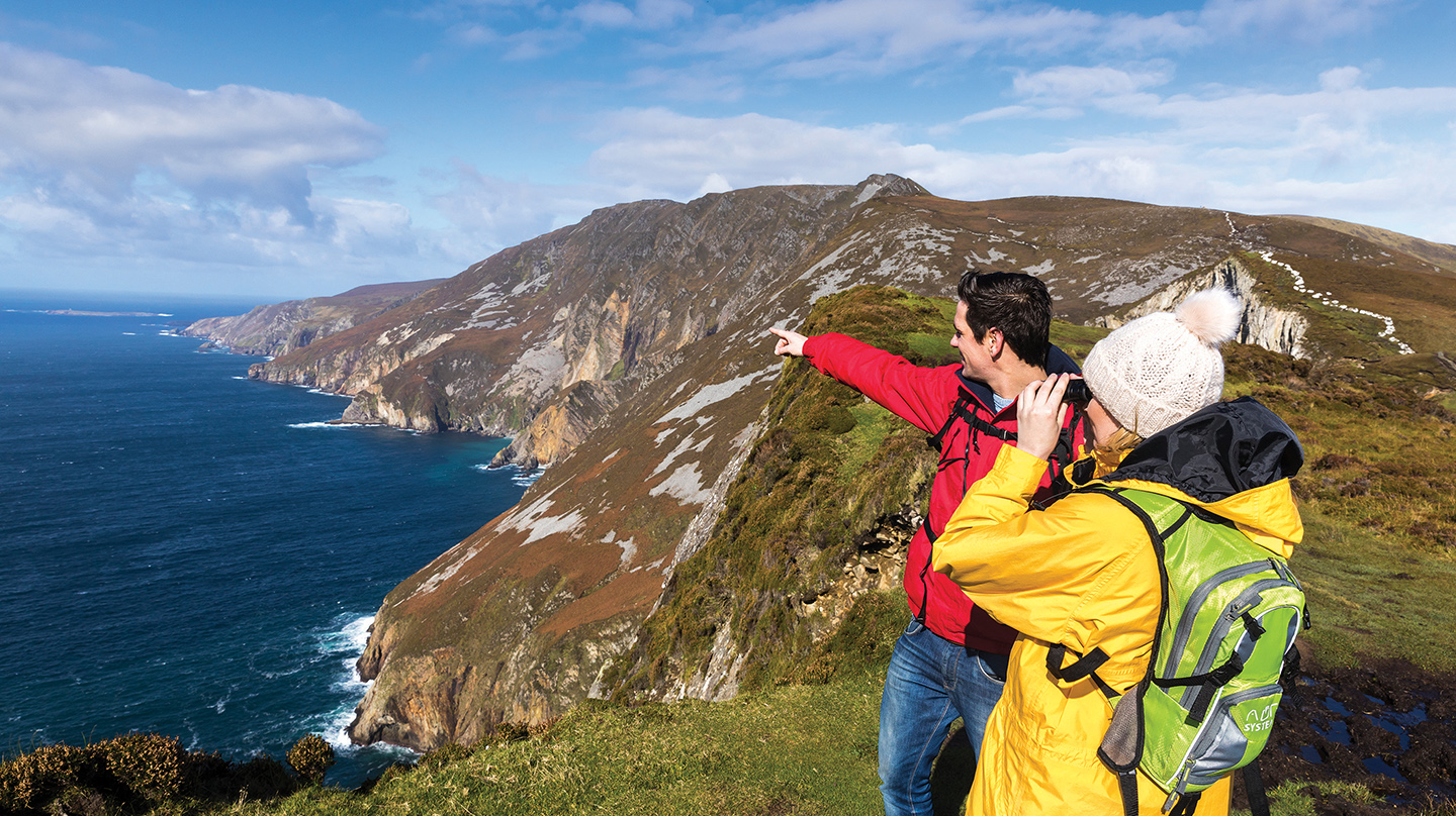 Slieve League Cliffs - a couple admires the oceanside cliffs 