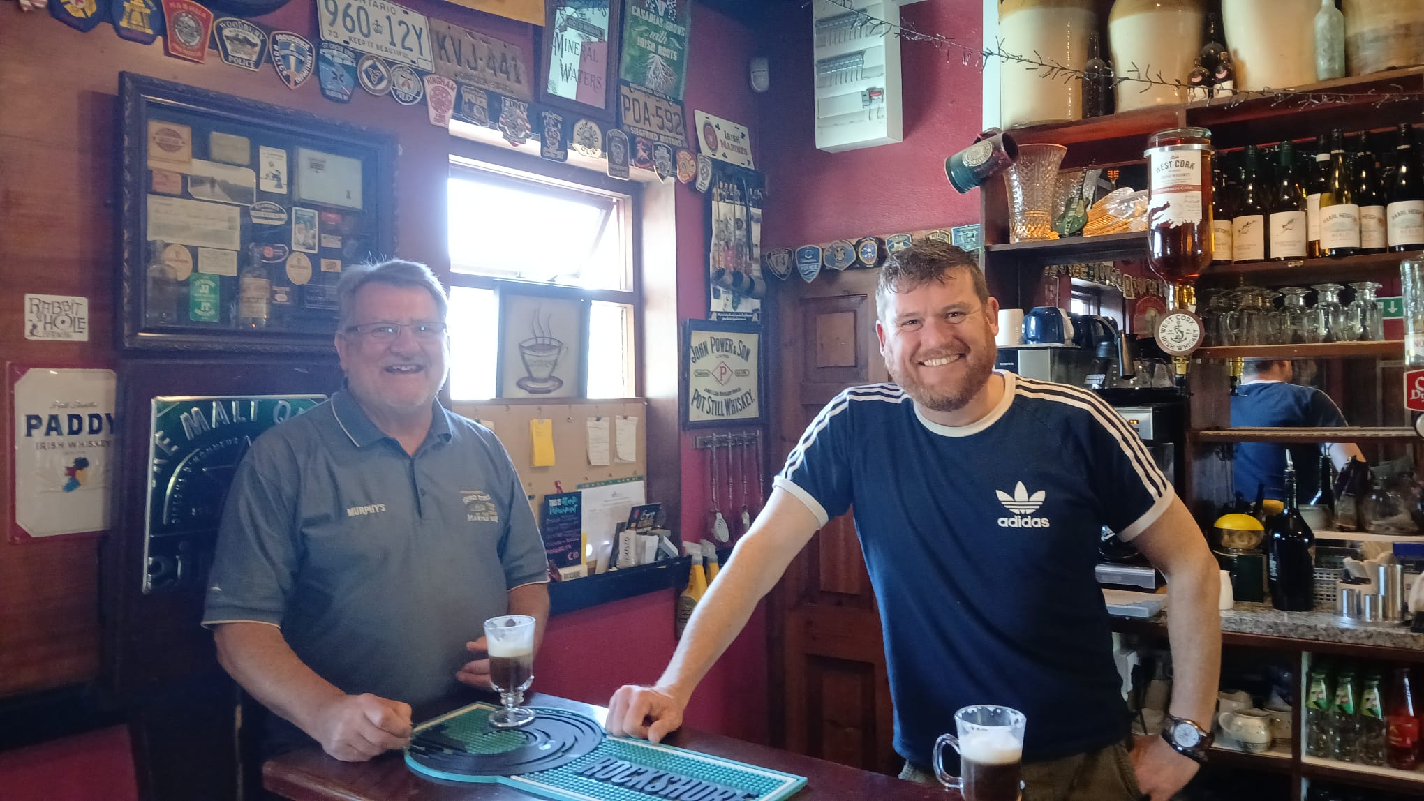 Christy and Eoghan O'Neill behind the bar at the Marine Bar, sipping Irish Coffees