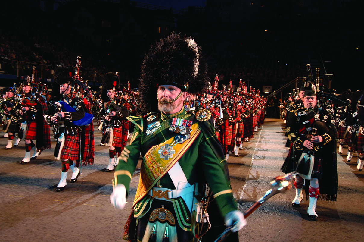 The pageantry of the Royal Military Tattoo with uniformed performers against the night sky of Edinburgh Castle.
