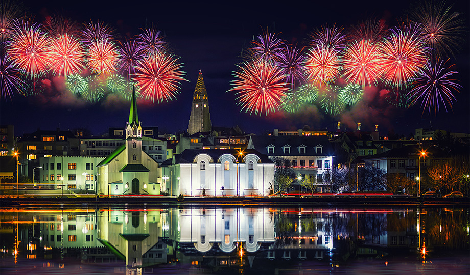 A city scene with holiday lights and firworks