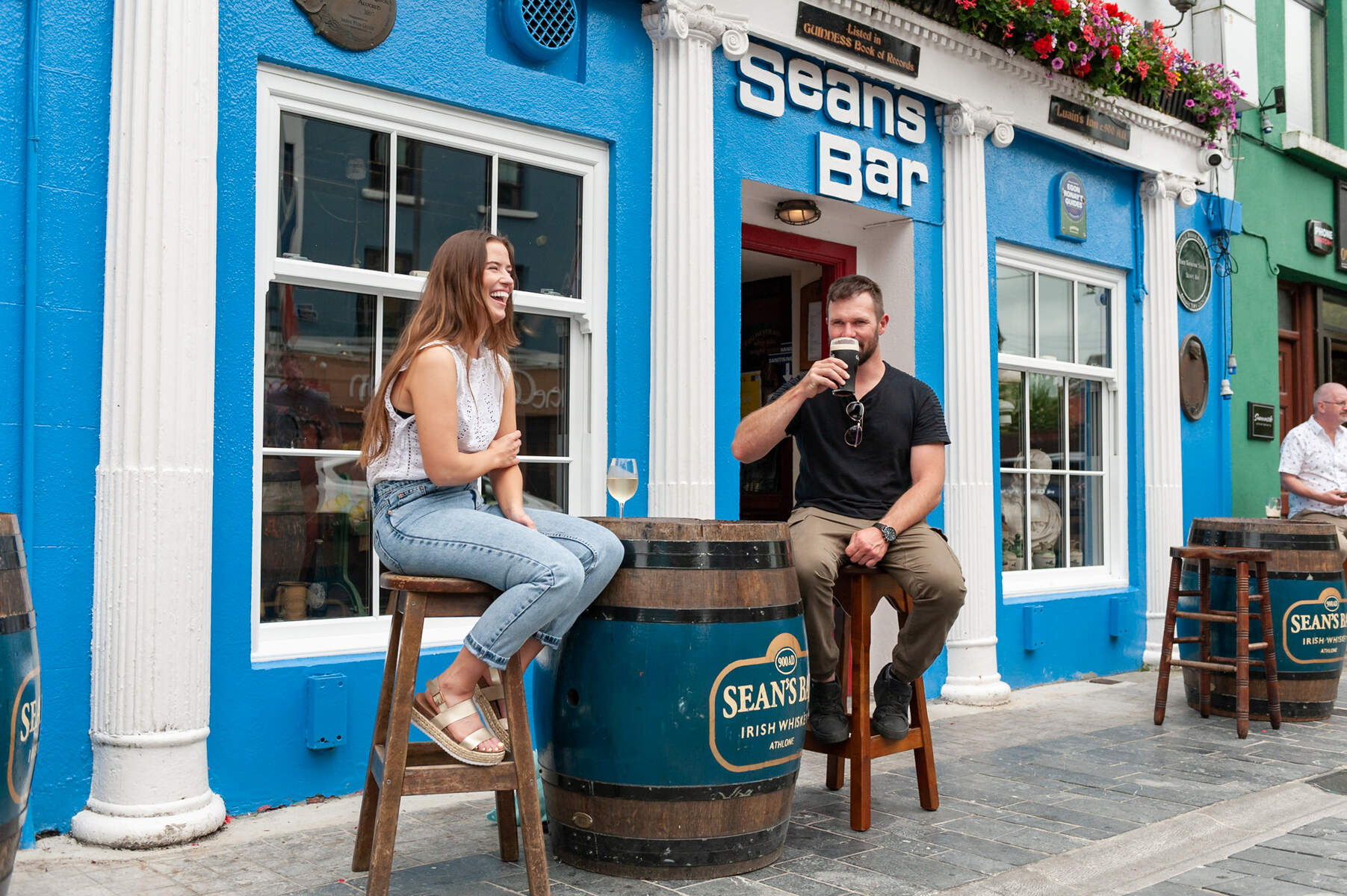 Two guests having drinks outside Sean's BAr