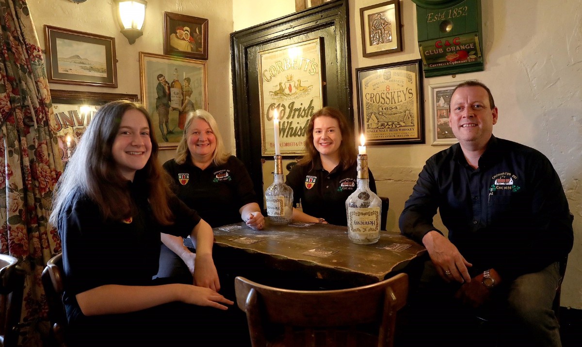 The Hurl family, owners of Crosskeys Inn, sitting at a table in the pub