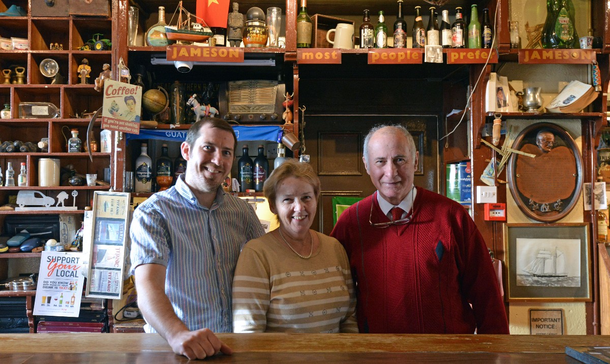 The family owners smiling behind the bar at The Glyde Inn