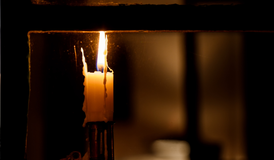 A taper candle seen through a window
