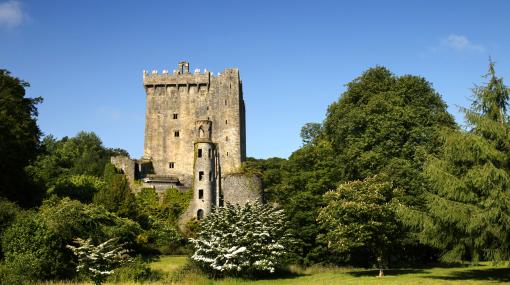 Blarney Castle in County Cork, a medieval castle in the sunshine surrounded by greenery