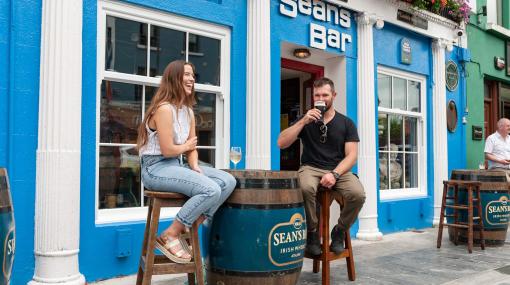 Two people share a drink outside Sean's Bar in Athlone