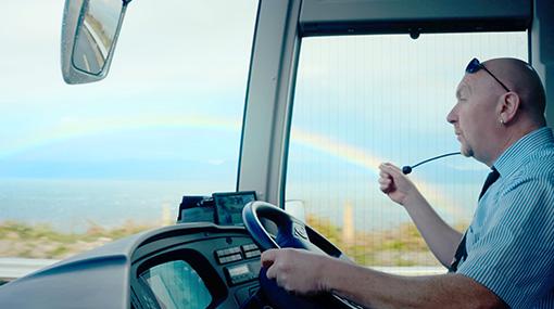 CIE Tours tour director speaking to guests while traveling by coach